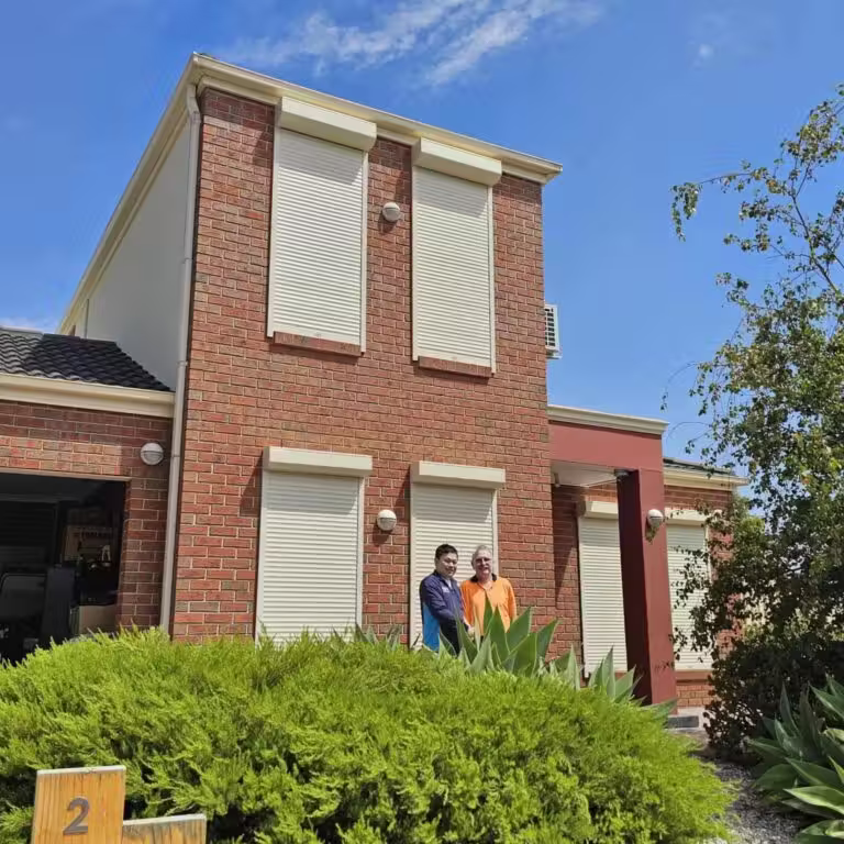 Cream roller shutters installed on upper floor windows of a two-storey Melbourne home by SM Roller Shutters