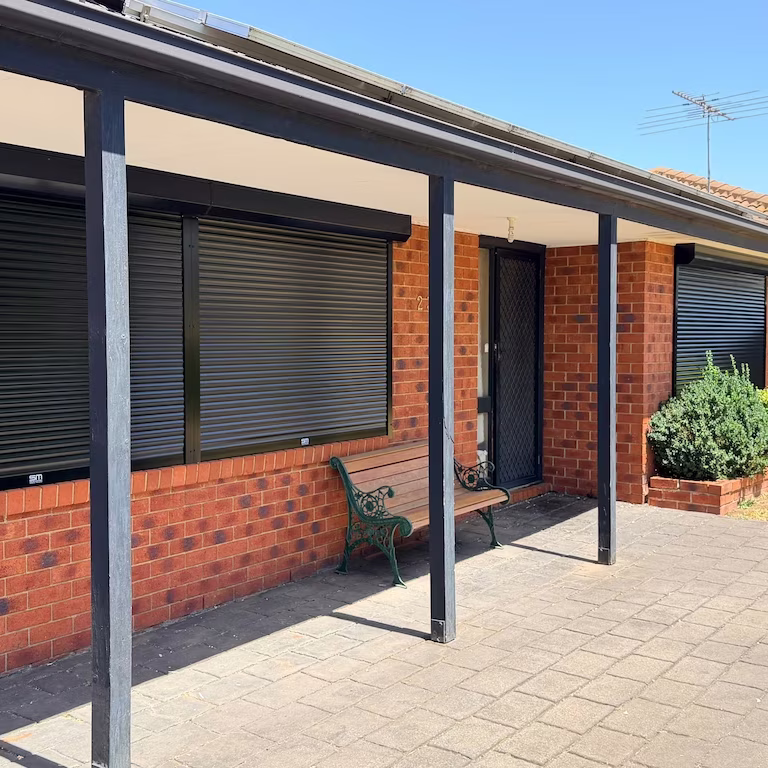 Noise reduction roller shutters fitted to a brick veneer home verandah in Melbourne with closed slats blocking street noise